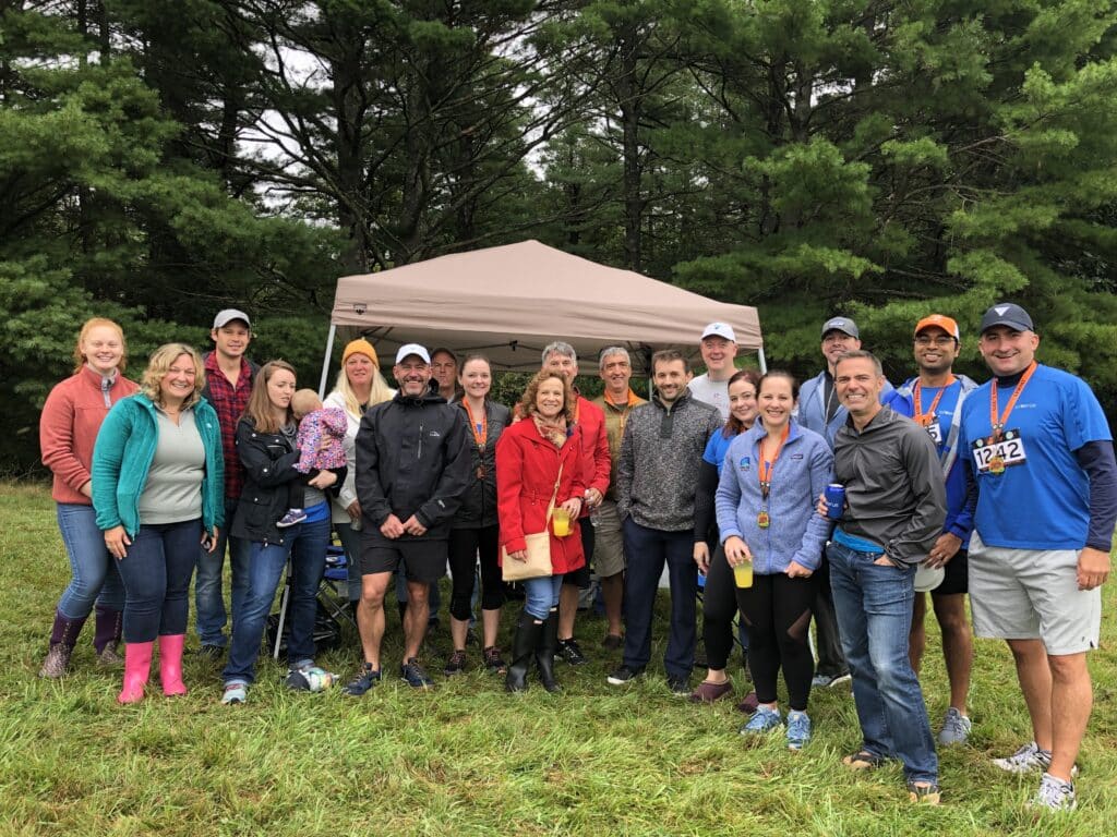 Triverus team taking group photo outdoors in front of tent